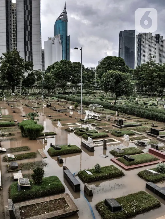 Banjir merendam Taman Pemakaman Umum (TPU) Karet Bivak, Jakarta, pada Minggu (7/2/2021). Banjir yang terjadi di TPU Karet Bivak untuk kedua kalinya tersebut juga menyulitkan mereka yang ingin melakukan ziarah ke makam keluarga maupun kerabat. (merdeka.com/Iqbal Nugroho)