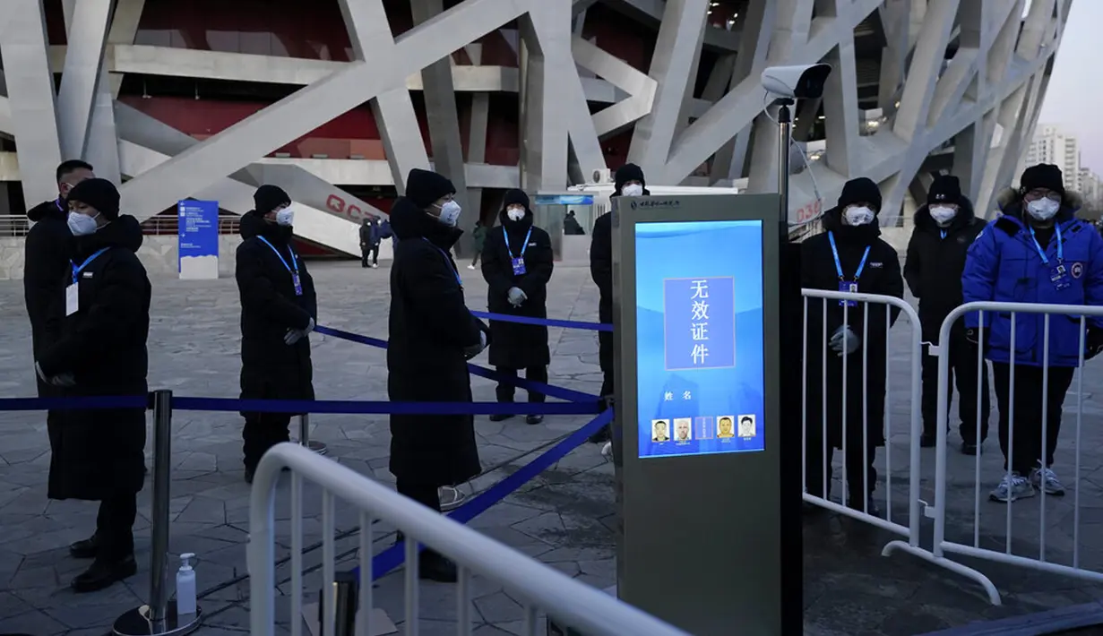 Penjaga keamanan berdiri di luar Stadion Nasional yang dikenal sebagai Sarang Burung jelang upacara pembukaan Olimpiade Musim Dingin 2022 di Beijing, China, Jumat (4/2/2022). Upacara pembukaan Olimpiade Musim Dingin 2022 akan digelar malam ini. (AP Photo/Jae C.Hong)
