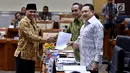 Ketua KPK Agus Rahardjo menyerahkan daftar barang sitaan kepada pimpinan rapat dengar pendapat (RDP) Komisi III, Benny K. Harman di gedung DPR, Senayan, Jakarta, Selasa (26/9). Rapat tersebut membahas evaluasi kinerja KPK. (Liputan6.com/Johan Tallo)
