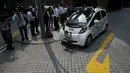 Awak media saat melihat kendaraan self-driving otonom pada demonstrasi di sebuah taman Singapura, Senin (12/10). Mobil dan bus di jalanan tanpa sopir ini sudah menjadi program panjang Singapura untuk menciptakan kendaraan umum autopilot.(REUTERS/Edgar Su)