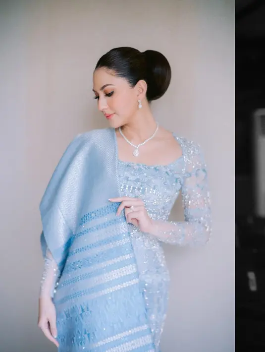 Berbeda lagi ketika Jessica Mila menjalani prosesi pertunangan khas adat Batak. Kali ini, ia memilih kebaya super cantik berwarna biru terang yang lembut, dipadu kain Ulos sebagai selendang rok yang serasi. Foto: Instagram.