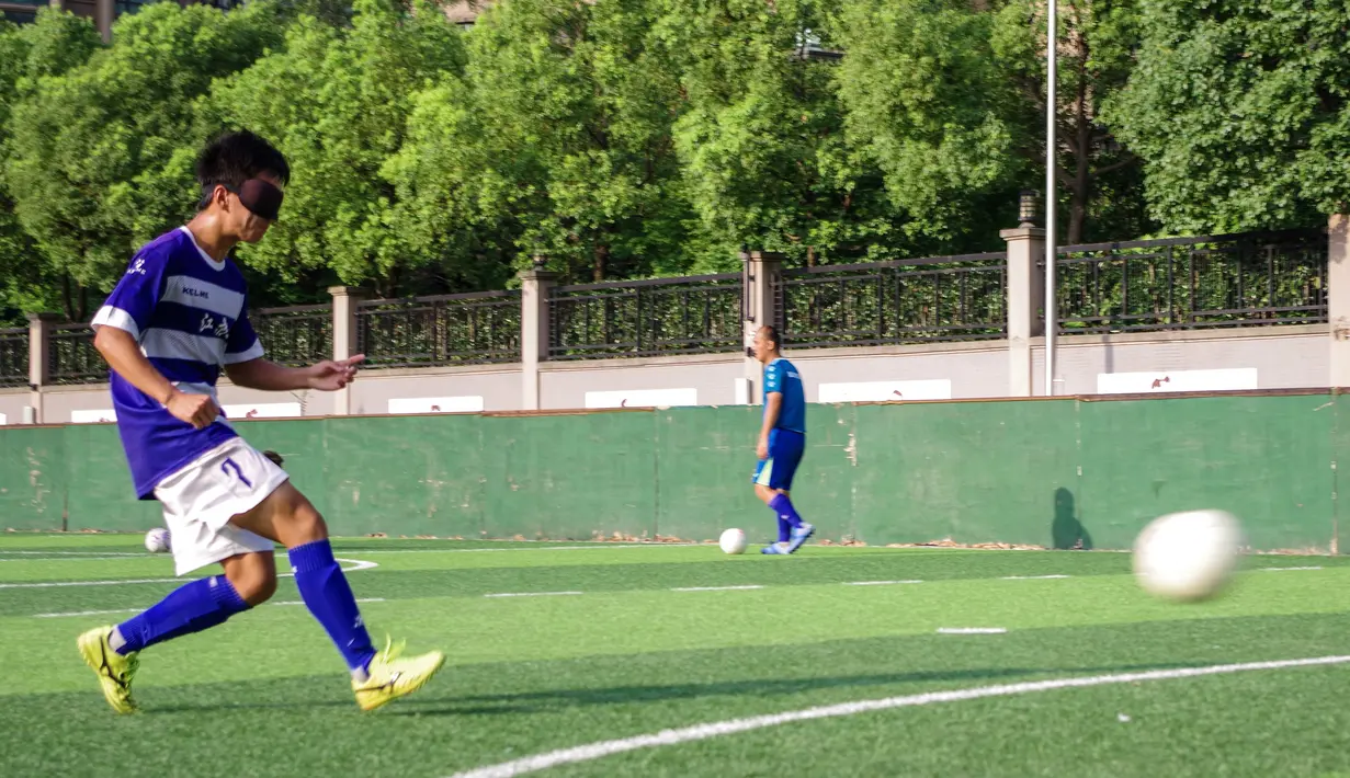 Seorang pemain tim sepak bola tunanetra Provinsi Jiangsu menendang bola selama sesi pelatihan Nantong di provinsi Jiangsu timur China (19/8/2019). Tim yang pemainnya penyandang tunanetra ini tidak perlu khawatir jika cedera, mereka semua adalah tukang pijat. (Cheng Yajing/Jiangsu Provincial Blind Fo