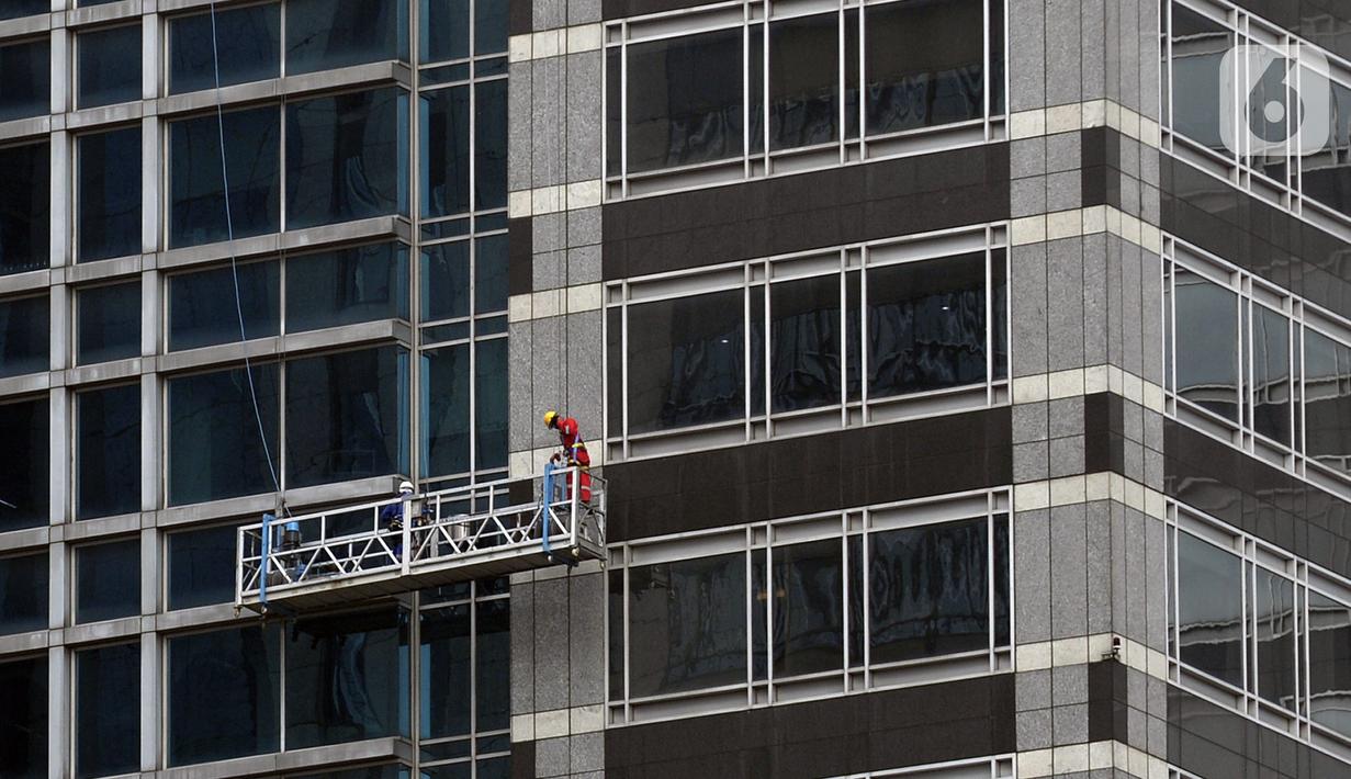 Pekerja membersihkan kaca gedung bertingkat di kawasan Sudirman Central Business District (SCBD), Jakarta, Senin (8/6/2020). Hampir tiga bulan kebijakan work from home (WFH) akibat pandemi COVID-19, banyak gedung bertingkat tidak terawat hari ini mulai dibersihkan. (merdeka.com/Dwi Narwoko)