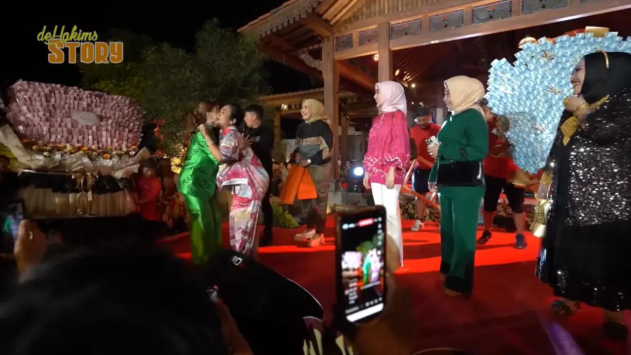 Di depan panggung tampak ada kado-kado berupa uang yang dihias sedemikian rupa. Tampak uang-uang tersebut ada pecahan Rp50 ribu. Selain itu juga ada uang pecahan Rp100 ribu.<br>