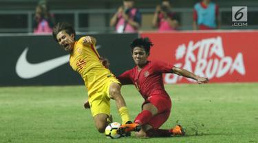 Bek Timnas Indonesia U-19, Firza Andika (kanan) berebut bola dengan pemain China U-19, Qinhan Sun pada laga PSSI 88th U-19 International Tournament di Stadion Pakansari, Cibinong, Selasa (25/9). Indonesia kalah 0-3. (Liputan6.com/Helmi Fithriansyah)