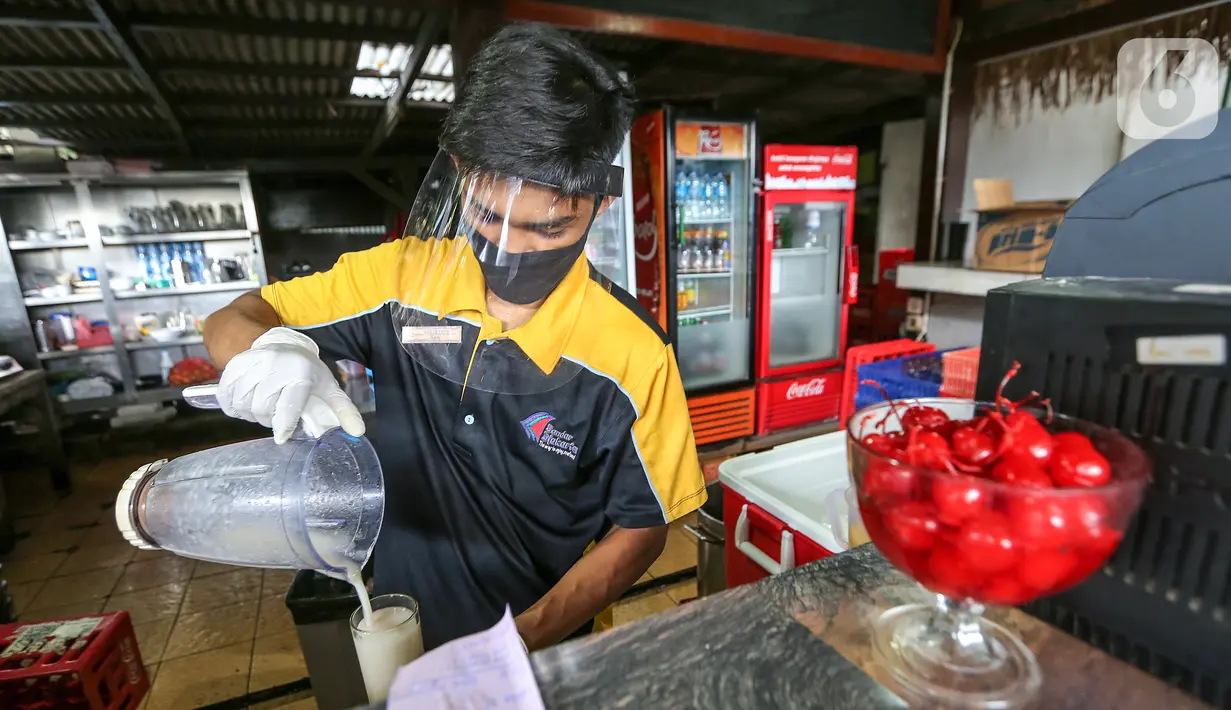 Pramusaji lengkap dengan APD berupa face shield, sarung tangan dan masker membuat jus buah di Restoran Bandar Djakarta, Alam Sutera, Tangsel, Rabu (10/6/2020). Sambut new normal PSBB Tangerang Raya diperpanjang hingga 15 Juni dengan menerapkan protokol kesehatan. (Liputan6.com/Fery Pradolo)