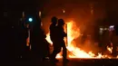 Polisi anti huru hara berjalan menghadapi massa yang melakukan pembakaran di Vieux Port di Marseille, Prancis (16/5). Kerusuhan ini disebabkan oleh fans Marseille yang tidak terima timnya kalah dalam final Liga Europa. (AFP Photo/Bertrand Langlois)