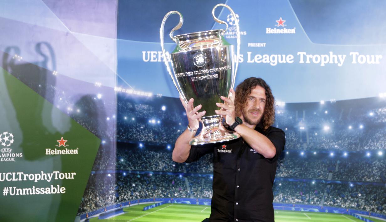 Legenda Barcelona, Carles Puyol, mengangkat trofi Liga Champions saat jumpa fans di Jakarta, Senin (11/3). Jumpa fans ini dalam rangka UEFA Champions League Trophy Tour di Indonesia. (Bola.com/Vitalis Yogi Trisna)