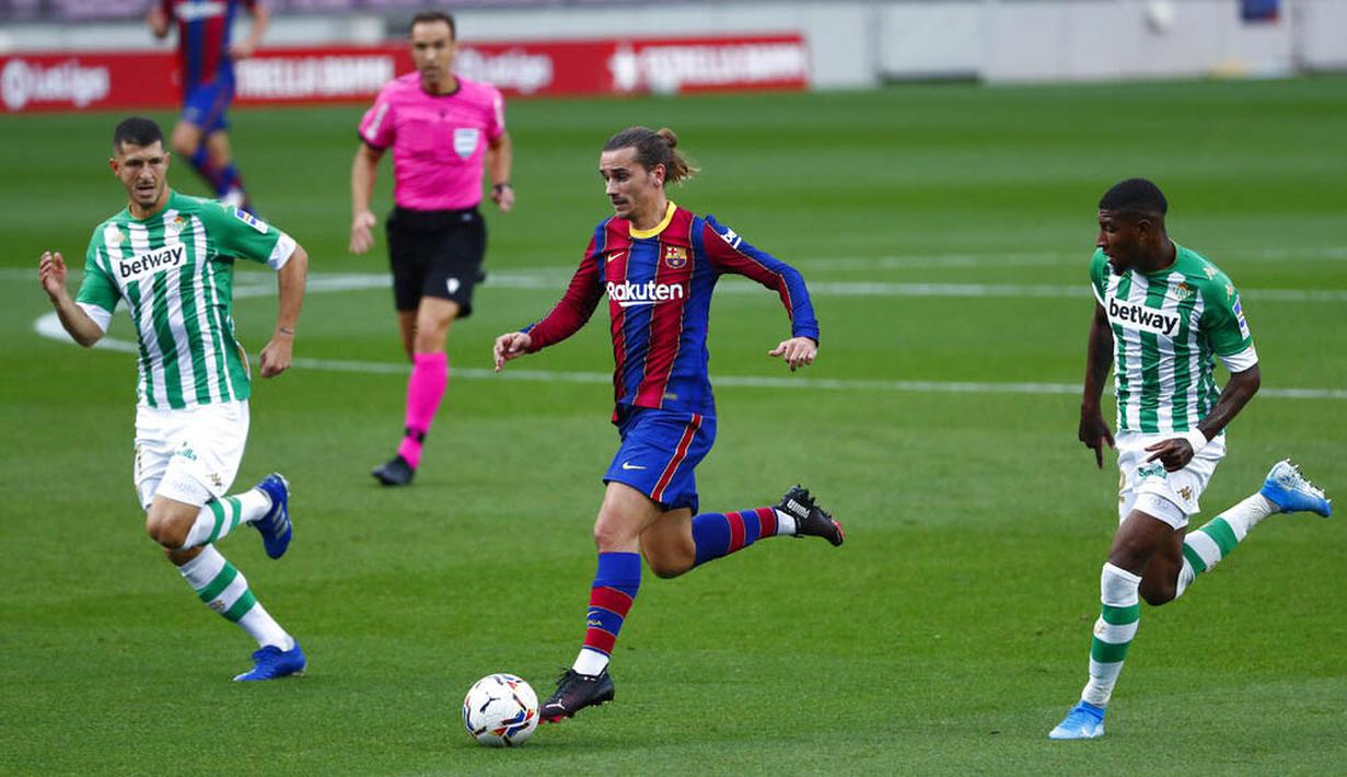 Penyerang Barcelona, Antoine Griezmann, menggiring bola saat melawan Real Betis pada laga La Liga di Stadion Camp Nou, Sabtu (7/11/2020). Barca menang dengan skor 5-2.(AP/Joan Monfort)