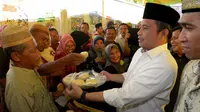 Menteri Desa, PDT dan Transmigrasi Marwan Jafar berbagi kue dengan warga saat melakukan kunjungan kerja ke daerah Gorontalo.