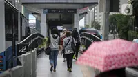 Sejumlah pekerja berjalan menuju halte di kawasan Jalan Sudirman, Jakarta, Selasa (2/11/2021). Sektor non-esensial kini boleh mempekerjakan hingga 75 persen karyawannya dari kantor. Sebelumnya, angka ini dibatasi hingga 50 persen. (Liputan6.com/Faizal Fanani)