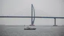 Sebuah kapal melintas di bawah Jembatan Hong Kong-Zhuhai-Makau (HKZM) di Zhuha (22/10). Jembatan laut terpanjang di dunia yang menghubungkan Hong Kong, Makau, dan daratan Cina ini akan dibuka untuk lalu lintas pada 24 Oktober 2018. (AFP Photo/Fred Dufour)