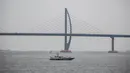 Sebuah kapal melintas di bawah Jembatan Hong Kong-Zhuhai-Makau (HKZM) di Zhuha (22/10). Jembatan laut terpanjang di dunia yang menghubungkan Hong Kong, Makau, dan daratan Cina ini akan dibuka untuk lalu lintas pada 24 Oktober 2018. (AFP Photo/Fred Dufour)