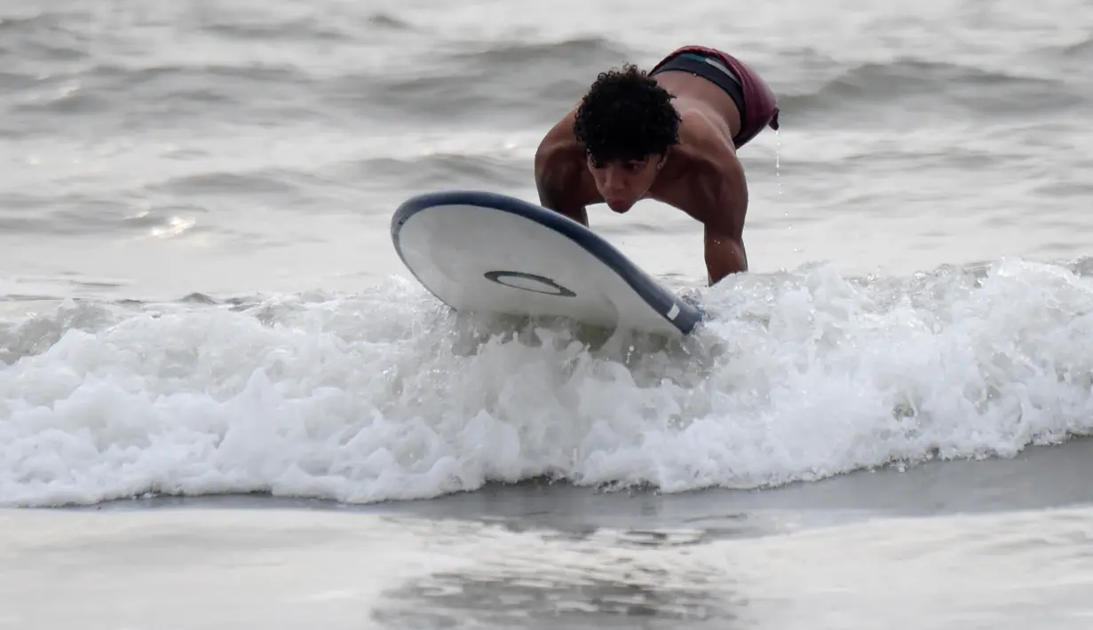Imigran Venezuela, Alfonso Mendoza alias Alca bermain surfing di Puerto, Kolombia, 27 September 2018. Keinginan Alca untuk bunuh diri terbesit ketika dia berusia 13 tahun dan mendapat intimidasi di sekolahnya. (Raul ARBOLEDA/AFP)