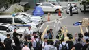 Jurnalis berkumpul saat kepolisian olah TKP lokasi bunuh diri anggota parlemen terkemuka Korea Selatan, Roh Hoe-chan di dekat gerbang apartemen, Seoul, Senin (23/7). Roh bunuh diri di tengah penyelidikan skandal suap yang melibatkan dirinya. (AFP/ YONHAP)