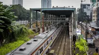 Rangkaian KRL Commuter Line melintas di proyek pembangunan stasiun kereta Bandara Soekarno-Hatta di Stasiun Sudirman Baru, Jakarta, Jumat (19/5). (Liputan6.com/Faizal Fanani)