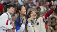 Pebulu tangkis tunggal putri Indonesia, Gregoria Mariska Tunjung sukses menyumbang medali pertama bagi kontingen Indonesia di Olimpiade Paris 2024. Medali perunggu yang didapatnya tanpa harus bertanding menghadapi Carolina Marin yang mundur akibat cedera di semifinal, dirayakan Jorji di atas podium juara dengan berswafoto dengan peraih medali emas, An Se-young dan peraih medali perak, He Bing Jiao saat upacara penyerahan medali di Porte de La Chapelle Arena, Paris, Senin (5/8/2024). (AP Photo/Kin Cheung)