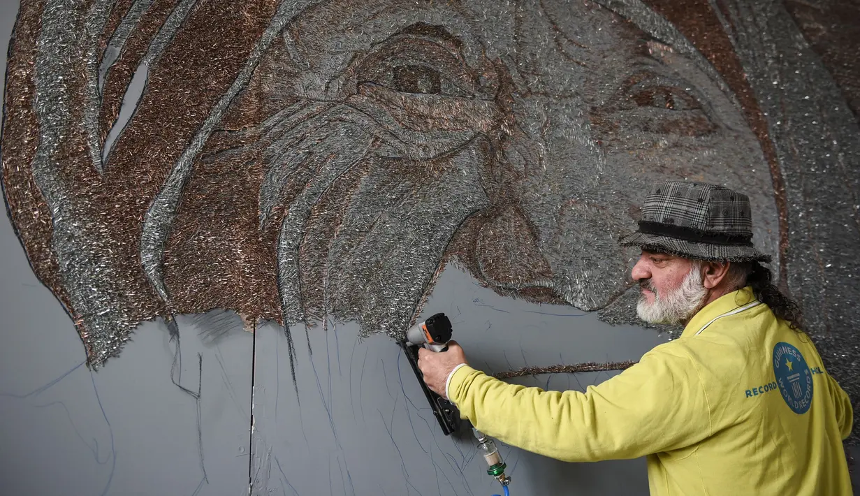 Saimir Strati saat berkarya membuat mosaik wajah Suster Teresa menggunakan staples di Museum Pristina, Kosovo (16/11). Sebelumnya Saimir juga telah menciptakan beberapa mosaik yang mengesankan dari berbagai media. (AFP/Armend Nimani)