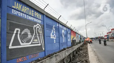 Pengendara melintas saat petugas Penanganan Prasaranan dan Sarana Umum (PPSU) menyelesaikan pembuatan mural di Jalan RE Martadinata, Tanjung Priok, Jakarta Utara, Selasa (24/5/2022). Pembuatan mural di sepanjang Jalan RE Martadinata yang dilakukan oleh petugas PPSU dari 19 kelurahan di Jakarta Utara tersebut dalam rangka menyambut balapan Formula E dan HUT ke-495 Kota Jakarta. (merdeka.com/Iqbal S Nugroho)