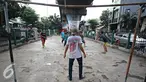 Sejumlah remaja bermain sepak bola di kolong rel kereta kawasan Juanda, Jakarta, Jumat (27/5). Tidak tersedianya ruang terbuka menyebabkan lahan tersebut dijadikan tempat bersosialisasi bagi warga. (Liputan6.com/Immanuel Antonius)