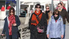 Orang-orang yang tidak mengenakan masker berjalan di Saint-Jean-de-Luz, barat daya Prancis, Rabu (2/2/2022). Inggris, Prancis, Irlandia, Belanda, dan beberapa negara Nordik telah mengambil langkah-langkah untuk mengakhiri atau melonggarkan pembatasan COVID-19 mereka.  (AP Photo/Bob Edme)
