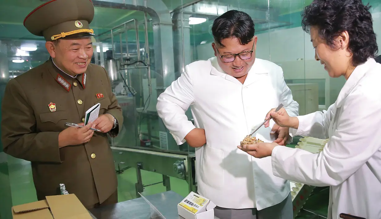 Tawa Pemimpin Korea Utara Kim Jong-un (tengah) saat mengunjungi Pabrik No. 525 di Korea Utara, Rabu (25/7). Pabrik No. 525 memproduksi makanan khusus atau ransum untuk tentara Korea Utara. (STRINGER/AFP/KCNA VIA KNS)
