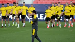 Pelatih Borussia Dortmund, Edin Terzic melihat pemainnya berlatih selama sesi latihan tim di stadion Ramon Sanchez Pizjuan di Seville (16/2/2021). Los Palanganas maupun Die Borussen sendiri terakhir kali bertemu pada musim 2009-2010 di ajang Liga Europa. (AFP/Cristina Quicler)