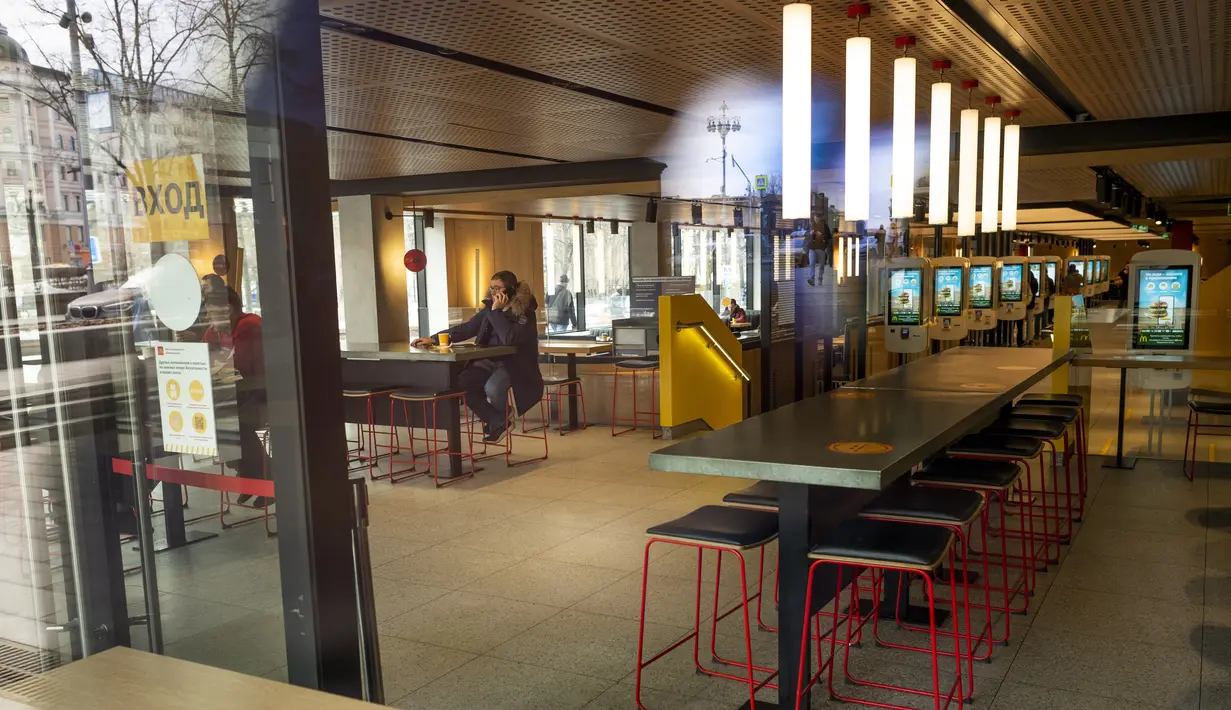 Sejumlah pengunjung terlihat melalui jendela restoran McDonald's pada hari kerja terakhirnya di Pushkinskaya Square di Moskow, Senin (14/3/2022). Gerai makanan cepat saji McDonald’s memutuskan setop beroperasi dari Rusia pasca invasi yang dilakukan Negeri Beruang Merah terhadap Ukraina. (AP Photo)