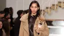 Seorang model menggendong anak anjing saat memamerkan rancangan Tod's di Milan Fashion Week, Milan, Italia, Jumat (23/2). Selain Gigi Hadid, model Tod's lainnya juga membawa anak anjing saat tampil di Milan Fashion Week. (Matteo Bazzi/ANSA via AP)