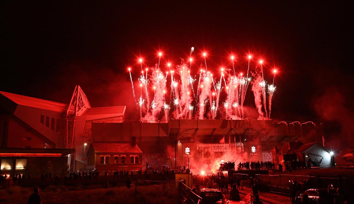 Pertunjukan kembang api menerangi Stadion Anfield saat perayaan trofi juara Premier League usai pertandingan Liverpool melawan Chelsea, Kamis (23/7/2020) dini hari WIB. Fans Liverpool tetap berdatangan ke area Stadion Anfield meski ada permintaan untuk merayakan di rumah. (AFP/Oli Scarff)
