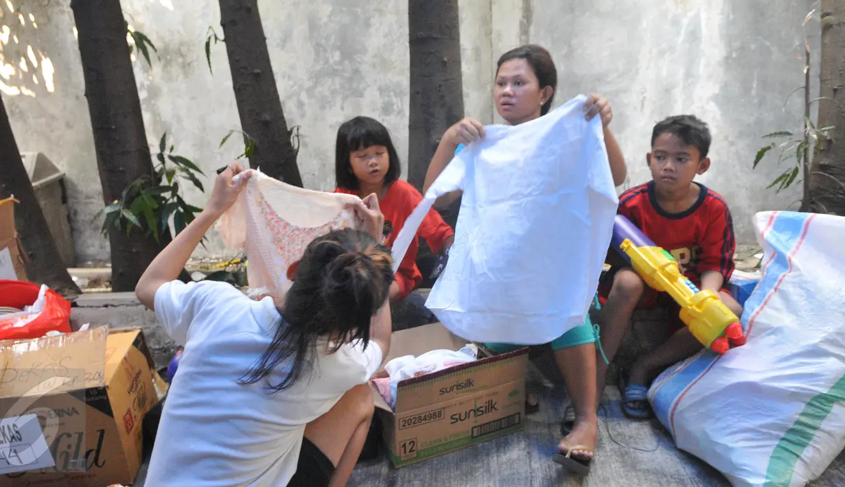 Sejumlah warga berhasil mendapatkan barang yang mereka inginkan, Jakarta, Minggu (21/6/2015). Warga terlihat  antusias membeli pakaian di pasar murah tersebut. (Liputan6.com/Herman Zakharia)