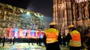 Petugas keamanan berjaga di depan gedung Katedral Cologne yang dihiasi instalasi cahaya, Jerman (31/12). Mereka punya caranya masing-masing untuk merayakan tahun baru, di Jerman mereka menikmati kilauan cahaya. (AFP/Patrik Stollarz)