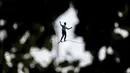 Akrobatik Prancis Nathan Paulin mencoba berjalan meniti seutas tali slackline dari Menara Eiffel melintasi Sungai Seine, di Paris, Minggu (19/9/2021). Pada 2019, pria Prancis itu melakukan slackline walk setinggi 150 meter dengan panjang 510 meter. (AP Photo/Lewis Joly)