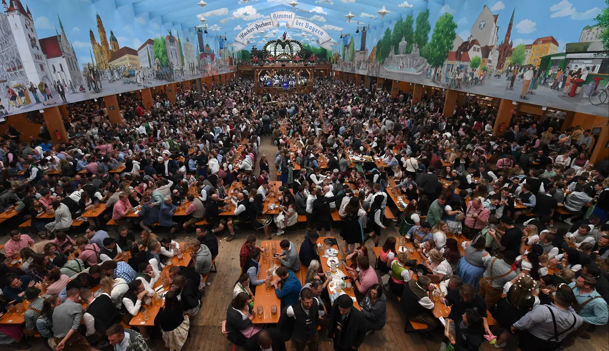 Pengunjung menikmati bir selama Festival Oktoberfest 2019 di sebuah tenda di Munich, Jerman selatan (3/10/2019). Festival bir terbesar di dunia Oktoberfest berlangsung hingga 6 Oktober 2019. (AFP Photo/Christof Stache)