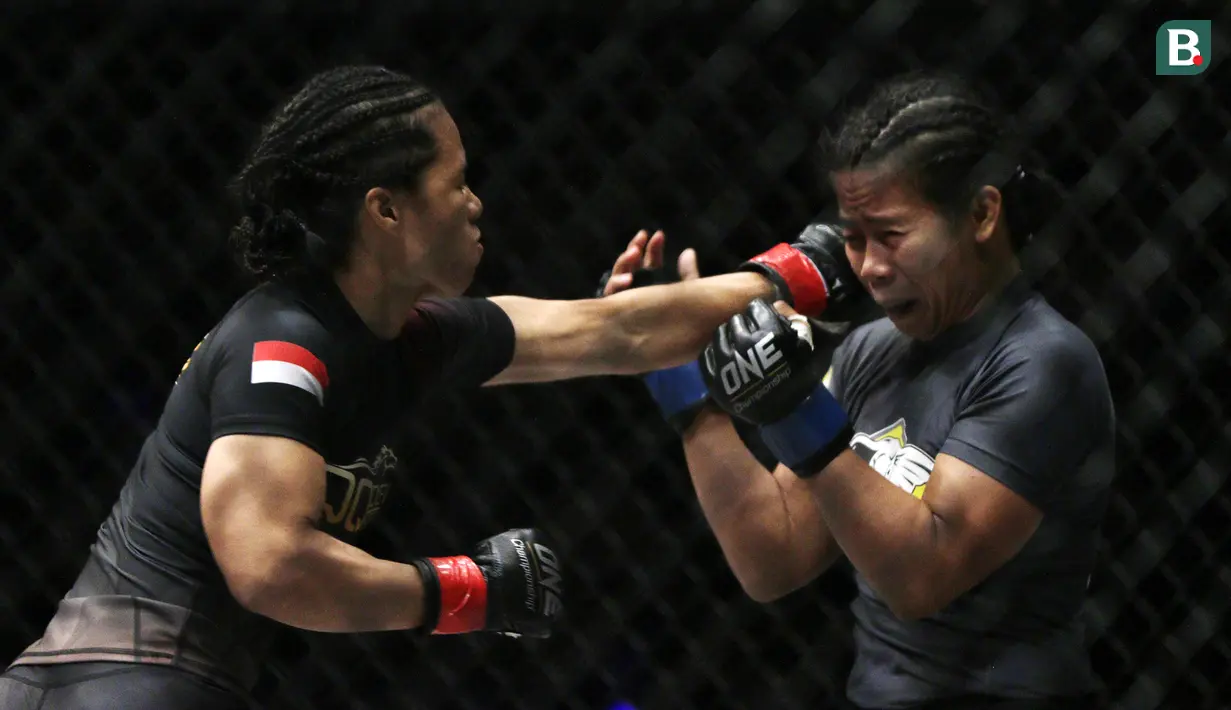 Petarung Indonesia, Priscilla Lumban Gaol, memukul petarung Filipina, Angelie Sabanal, pada laga One Championship di Istora Senayan, Jakarta, Sabtu (17/11). Priscilla meraih kemenangan angka di kelas atomweight. (Bola.com/Yoppy Renato)