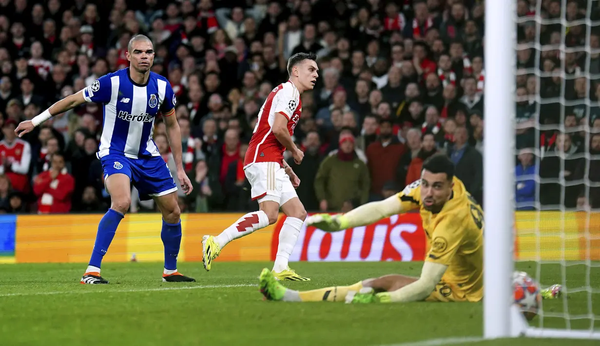 Pemain Arsenal, Leandro Trossard (tengah) mencetak gol ke gawang Porto pada laga leg kedua 16 besar Liga Champions 2023/2024 di Emirates Stadium, London, Inggris, Rabu (13/03/2024) dini hari WIB. (AP Photo/Zac Goodwin)