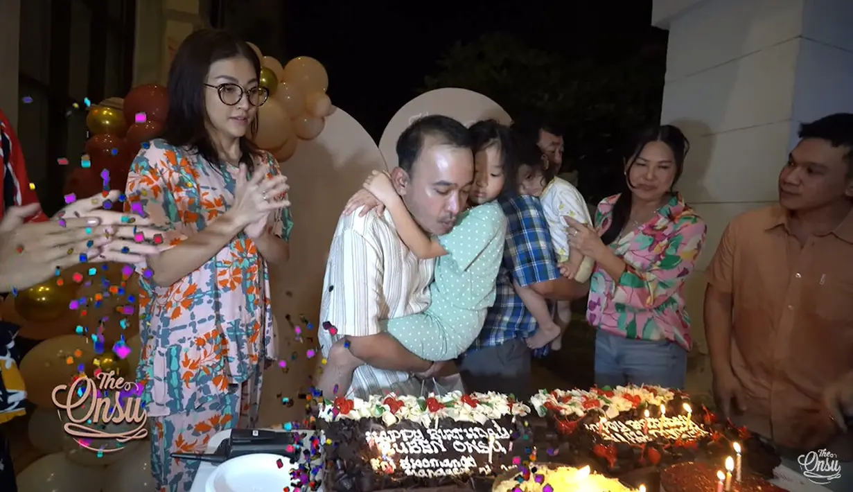 Ruben Onsu meniup lilin sambil meggendong putri pertamanya. (Foto: YouTube/ The Onsu Family)