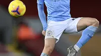 Gelandang Manchester City, Phil Foden mengontrol bola saat bertanding melawan Liverpool pada pertandingan lanjutan Liga Inggris di Stadion Anfield, Inggris, Senin (8/2/2021).  City menang telak atas Liverpool 4-1. (Laurence Griffiths/Pool via AP)