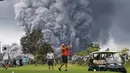 Orang-orang bermain golf saat kepulan asap abu vulkanik berembus dari puncak gunung Kiluaea di Big Island Hawaii (15/5). Letusan gunung tersebut tidak membuat sejumlah orang khawatir bahkan masih ada yang bermain golf. (AFP Photo/Mario Tama)
