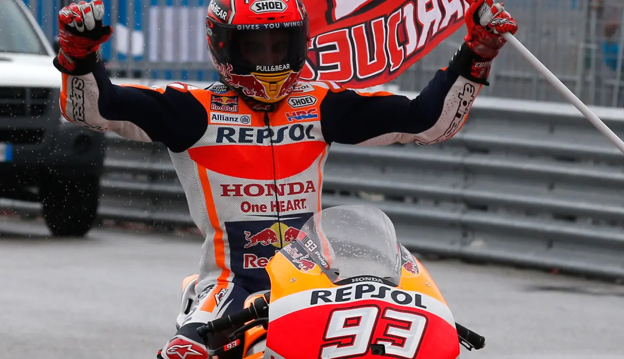 Pembalap Repsol Honda, Marc Marquez memegang bendera setelah keluar sebagai yang tercepat pada balapan MotoGP San Marino 2017 di Sirkuit Misano, Italia, Minggu (10/9). Bagi Marquez, ini merupakan kemenangan keempatnya musim ini. (AP Photo/Antonio Calanni)