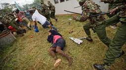 Seorang wanita tergeletak saat terjadi bentrokan antara pendukung Presiden Uhuru Kenyatta dan polisi di Nairobi, Kenya (28/11). Sebelumnya, pemilihan Presiden Kenya pada tahun ini penuh dengan kontroversi. (AP Photo / Ben Curtis)
