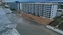 Dalam tampilan udara ini, tembok laut di sepanjang bangunan kondominium terlihat terhantam Badai Nicole di Pantai Daytona, Florida (10/11/2022). Badai Nicoler datang ke darat sebagai badai Kategori 1 sebelum melemah menjadi badai tropis saat bergerak melintasi negara bagian. (Joe Raedle/Getty Images/AFP)