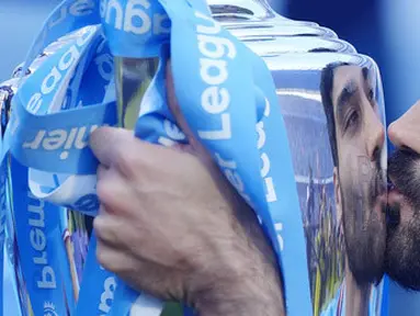 Pemain Manchester City, Ilkay Gundogan, mencium trofi saat perayaan juara Liga Inggris di Stadion Etihad, Minggu (21/5/2023). (AP Photo/Jon Super)