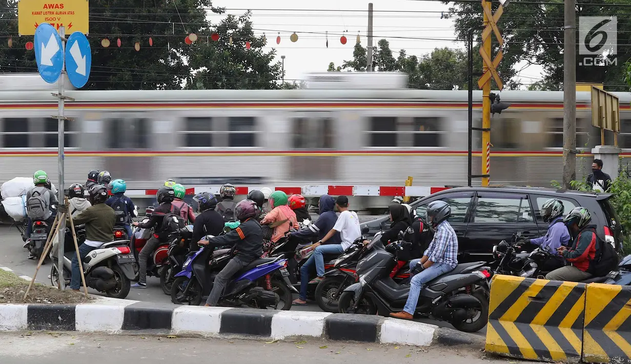 Kereta melintas di kawasan Lenteng Agung, Jakarta, Selasa (13/3). Untuk mengurai kemacetan imbas antrian kendaraan berputar balik di pintu kereta IISIP, Pemprov DKI berencana membangun flyover U-Turn di kawasan tersebut. (Liputan6.com/Immanuel Antonius)