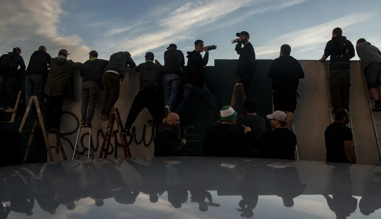 Suporter Bohemians 1905 menyaksikan pertandingan melawan Sparta Praha pada laga Liga Fortuna di Praha, Rep. Ceko (6/6/2020). Laga tertutup karena pembatasan virus corona tersebut membuat fans menonton dari balik tembok. (AFP/Michal Cizek)