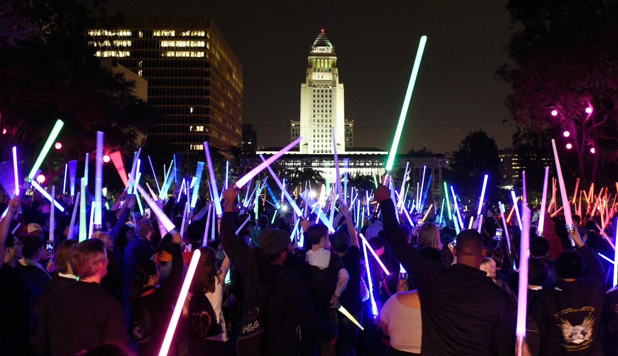Penggemar film Star Wars berkumpul sambil membawa lightsaber (pedang sinar) saat mengikuti Glow Battle Tour di Grand Park, Los Angeles (15/12). (Photo by Chris Pizzello/Invision/AP)