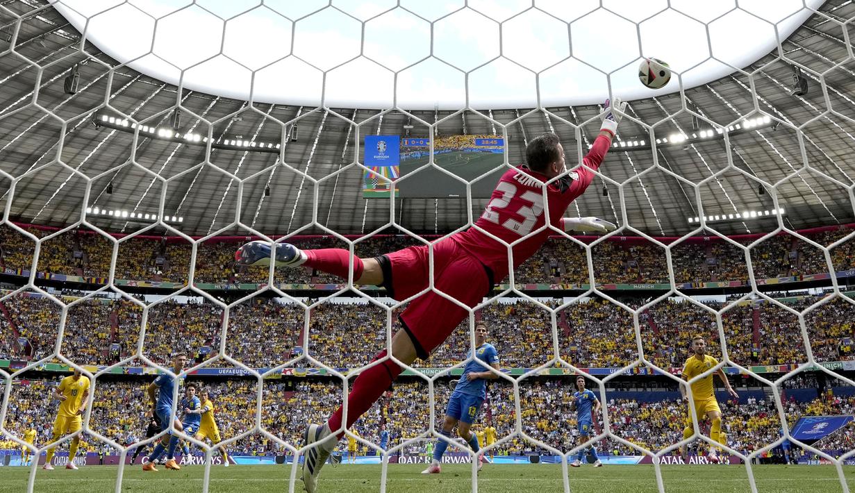 Kiper Timnas Ukraina, Andriy Lunin kebobolan gol pertama saat menghadapi Rumania tewat tendangan dari luar kotak penalti oleh Nicolae Stanciu pada laga Grup E Euro 2024 di Allianz Arena, Munchen, Jerman, Senin (17/6/2024). (AP Photo/Matthias Schrader)