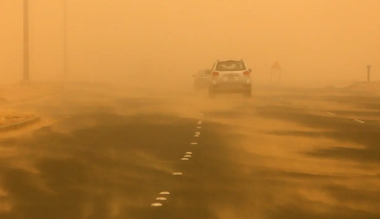 Kendaraan melintas di sepanjang jalan raya yang diselimuti debu tebal selama terjangan badai pasir di Kuwait City, Kuwait, pada 17 Juni 2021. Terjangan badai pasir ini membuat jarak pandang atau visibilitas di beberapa daerah turun hingga kurang dari 100 meter. (AFP/YasserAl-Zayyat)