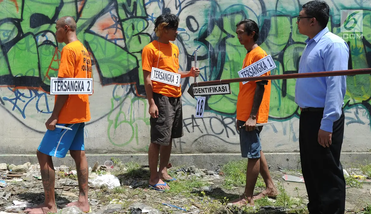 Sejumlah tersangka menjalani adegan rekonstruksi pembunuhan anak punk, MR (16), di perempatan Gaplek, Pamulang, Rabu (6/2). MR dibunuh secara kejam dengan cara ditusuk dan telinga serta kelingkingnya dipotong oleh para tersangka. (Merdeka.com/Arie Basuki)