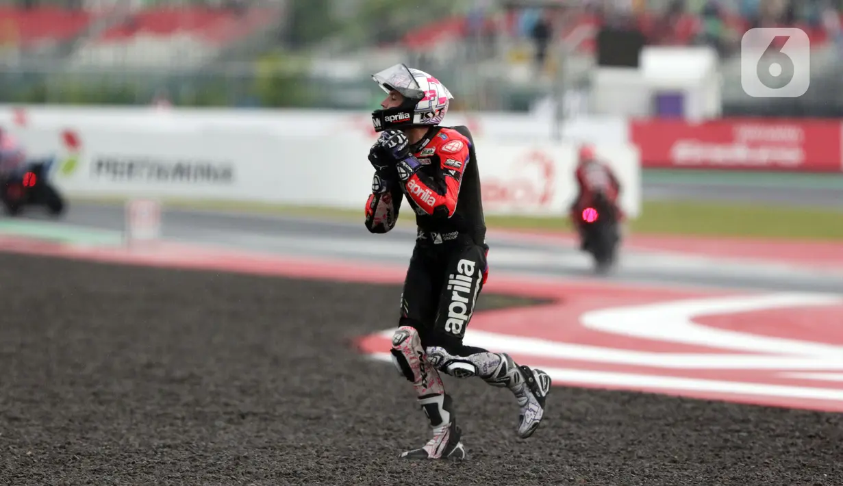 Pembalap Aprilia Racing, Aleix Espargaro berlari ke arah tribun penonton usai balapan MotoGP seri Pertamina Mandalika International Street Sirkuit, NTB, Minggu (20/3/2022). Aleix Espargaro menepati janjinya setelah meraih sejuta pengikut akun instagramnya. (Liputan6.com/Helmi Fithriansyah)